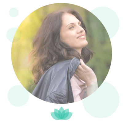 Woman smiling outdoors with yellow-green blurred background