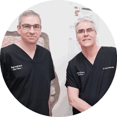 Two male dentists in black uniforms smiling at camera