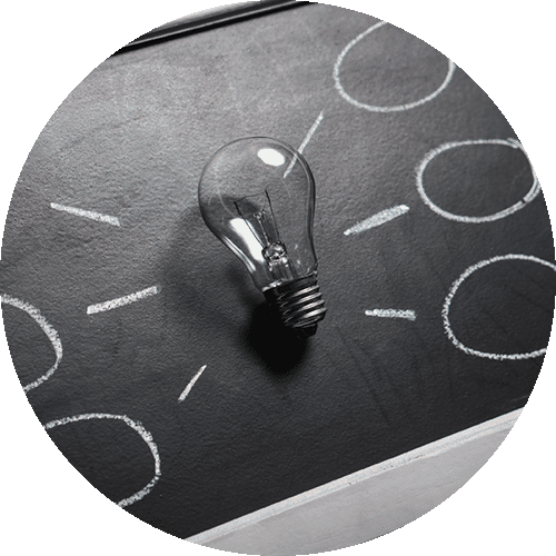 Light bulb on blackboard with chalk drawings and circles