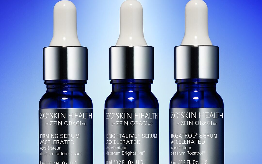 Three ZO Skin Health serum bottles with dropper caps on blue background